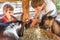 Two kids - boy and girl - taking care of domestic animals on far