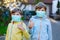 Two kids boys in medical mask as protection against pandemic coronavirus disease. Children, lovely siblings and best