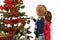 Two kids decorate Christmas tree