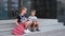 Two kids in eyeglasses with books and backpacks have a lunch