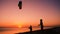 Two kids launching the rainbow kite together at sunset