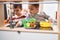 Two kids playing with play kitchen standing at kindergarten