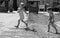 Two kids playing with water on paved city square