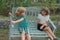 Two kids relaxing outdoors at summer park. Brother and sister happy walking in nature. Siblings boy and girl playing in