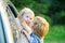 Two kids saying goodbye before car travel. Little boy gives kiss for cute girl. Good bye before car travel.