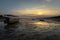 Two kids seating in boats stranded on sand at sunset, Nusa Ceningan