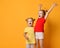 Two kids sisters standing screaming with hands up raised in red and yellow