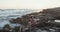 Two kids sitting on the beach during sunset