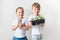 Two kids with sprouts and gardening tools, ecology theme on white background