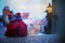 Two kids, standing on a stairs, holding a lantern, view of Prague behind them, snowy evening