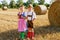 Two kids in traditional Bavarian costumes in wheat field. German children eating bread and pretzel during Oktoberfest