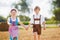 Two kids in traditional Bavarian costumes in wheat field. German children sitting on hay bale during Oktoberfest. Boy