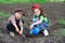 Two kids watering the sprout