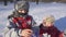 Two kids on winter park put on sticky snow glowes