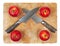 Two kinfes crossed on chopping board with apples