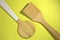 Two kitchen spatulas. On a yellow background