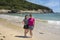 Two Korean female tourists standing barefooted on vacation on Sandy Beach in Bar Harbor, Maine.