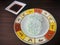 Two Kuih Lopes on a round plate with a diamond-shaped sweet sauce on the side, wooden background.