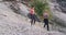 Two ladies with a fit body after a hard workout day through the mountain road thirsty drinking water from a plastic