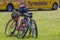 Two ladies mountain bikes lean against each other on grass in the sunshine