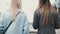 Two ladies walk up from a pedestrian tunnel. Back view close up blonde and brunette females in stylish clothes chatting.