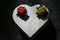 Two ladybugs made of plasticine on a wooden box in the form of a heart