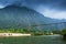 Two laos girls walking across the suspension bridge over the Nam Song River, fantastic cloudy and mountain range backdrop