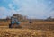 Two large blue tractor plow plowed land after harvesting the maize crop