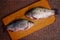 Two large crucian on a brown board in the kitchen