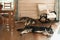 Two large dogs sleep on the wooden floor next to a rocking chair