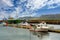 Two large fishing boats and many small boats moored at the harbor in the Icelandic countryside