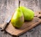 Two large fresh green pears and knife on a cutting