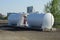 Two large industrial iron white barrels at a gas station