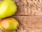 Two large juicy pears, green and red-green, on aged wooden table