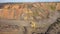 Two large mining dump truck going to meet each other on a dusty road aerial view.