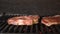 Two large raw juicy steaks on grill grill BBQ. Meat is grilled close-up. Dolly sliding video