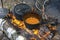 Two large smoky black bowls over a burning fire