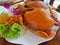 Two large steamed crabs in a white plate. Decorated with lettuce, carrots and orchids