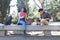 Two latin students smiling studying together sitting on a bench outdoors