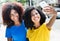 Two latin woman taking picture with phone