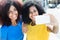 Two latin woman taking selfie with cellphone