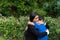 Two Latino brothers laughing and hugging each other in a park