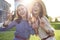 Two laughing beautiful women gesturing in the sunlight