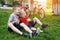 Two laughing boys having fun on the grass. Bicycles in the background