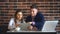 Two laughing coworkers discussing work project while on lunch break in cafeteria