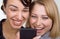 Two laughing women look at mobile phone