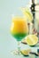 Two-layer alcoholic cocktail with mango juice, rum, liqueur, lime and ice, summer blue background, place for text