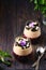 Two-layer jelly with a berry layer and a layer of almond milk panna cotta in transparent glasses on a dark wooden background.