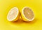 Two lemon halves fruit on a yellow background