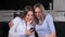 Two lesbian smiling best friends hugging at home and using the phone online app.